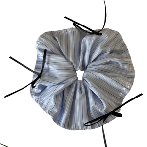 Ballet style blue striped hair scrunchie with black ribbons on a white background