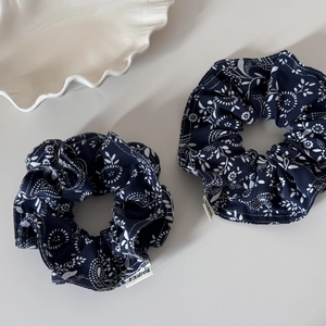 Close-up of navy blue floral and polka dot scrunchies made of soft cotton fabric