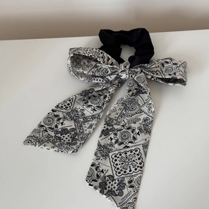 Detail view of oversized paisley print scrunchie with elegant long ribbon bow accessory