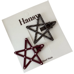 Set of two star hair clips with polka dots and stripes on a brand display card