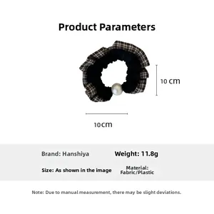 Detail showing checkered fabric texture and white pearl bead on elegant hair scrunchie