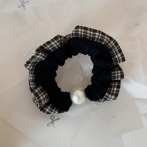 Detail of checkered edge hair scrunchie with a large white pearl and black fabric