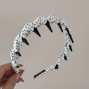 Détail du serre-tête à pois avec pointes décoratives et étiquette tissée interne