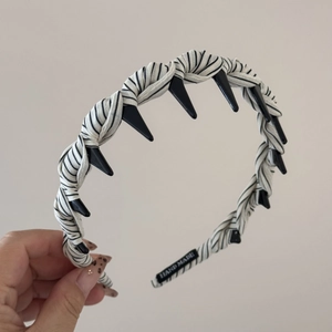 Détail d'un serre-tête rayé noir et blanc fait main avec des ornements pointus