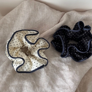 Detailed close-up of retro polka dot scrunchies with denim blue stitched edges