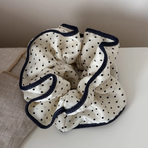 Detailed view of polka dot satin scrunchie with elegant denim trim and soft texture