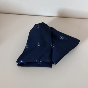 Detailansicht aus dunkelblauem Stoff mit weißen und hellblauen Sternmustern und weicher Textur