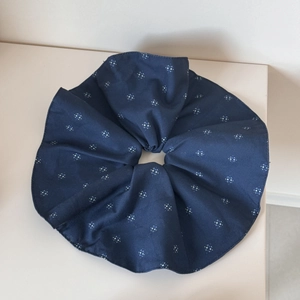 Detail eines blauen Haargummis mit Sternmuster zeigt Stofftextur und Faltenwurf