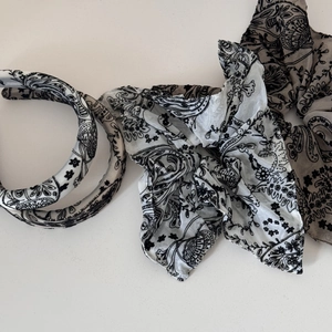 Detail view of paisley floral headband and hair scrunchies set in black and white tones