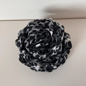 Detailed top view of layered leopard print fabric rose clip with soft textile texture