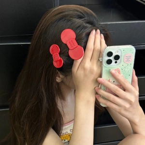 Detail of red acetate bow hair clips with WER WER lettering for women side hair styling