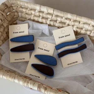 Détail de l'ensemble de barrettes en tissu bleu denim et marron sur carte