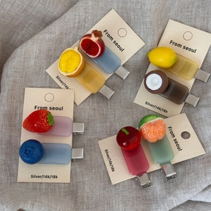 Detailed close-up of colorful resin fruit hair clips on cards for bangs styling