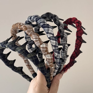 Detail showing various plaid fabric wrapped headbands with non-slip inner teeth design