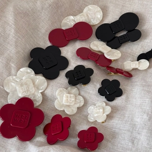Detail view of acetate flower and bow hair clips with gold metal duckbill alligator grips