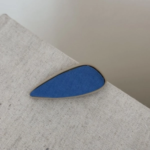 Gros plan détaillé d'une pince à cheveux en sergé bleu avec cadre en résine beige