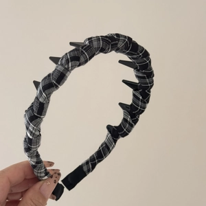 Detail of checkered fabric headband with small black teeth for secure hairstyle fixing