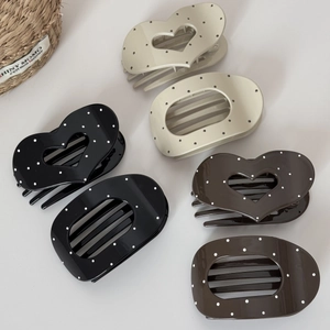 Close-up of heart and oval hair clips with polka dot patterns in neutral resin colors