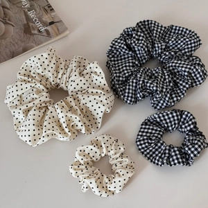 Dettaglio di quattro elastici per capelli in tessuto a quadri e pois bianco e nero
