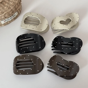 Polka dot pattern hair clips in heart and oval shapes on a white background