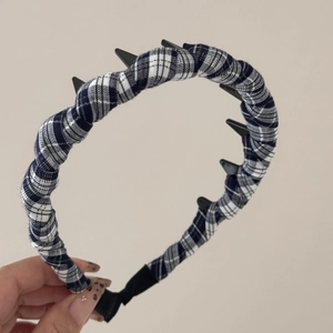 Detail of black and white plaid headband showing anti-slip inner teeth and fabric texture