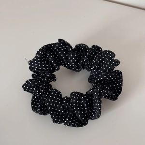 Close-up of black and white polka dot pattern on pleated elastic scrunchie fabric