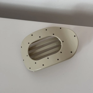 Close-up of cream polka dot hair claw clip made of durable resin for elegant hairstyling
