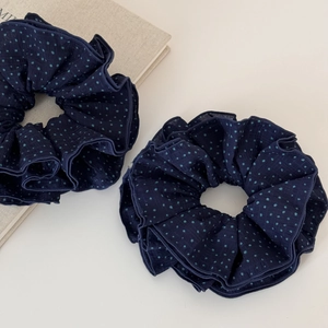Macro shot of navy blue polka dot scrunchies in textured sheer fabric and elegant pleats