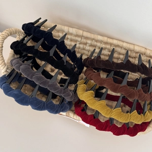 Detail of red and multi-color velvet headbands with non-slip teeth in a woven basket