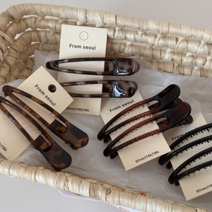 Close-up of leopard pattern hair clips and tortoiseshell duckbill clips on display