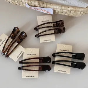 Leopard print and solid duckbill hair clips in tortoiseshell, black, and coffee brown