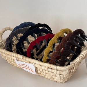 Close-up of retro velvet wave headbands with teeth in a woven basket