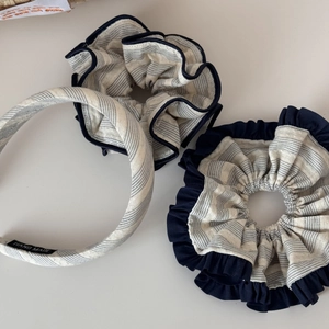 Detail view of striped scrunchies and headband set with a hand made woven label