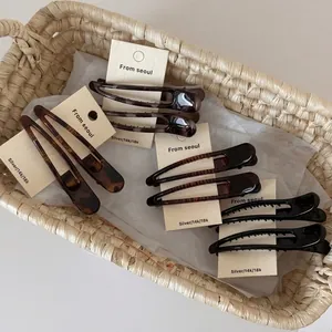 Set of leopard print and tortoiseshell resin hair clips on display card in a basket