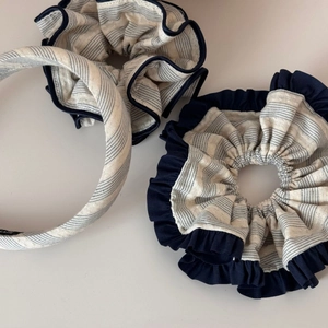 Detailed macro view of navy striped fabric hairband and scrunchies with pleated edges
