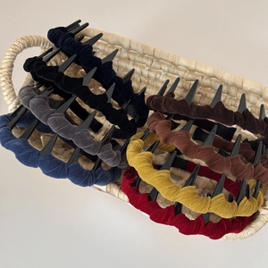 Detail of velvet wave headbands with teeth in various colors inside a woven basket