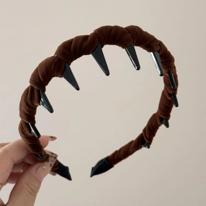Detailed view of dark brown velvet twisted headband with inner plastic teeth for secure grip
