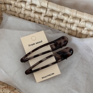 Detail of leopard print hair clips on display card with a soft woven background