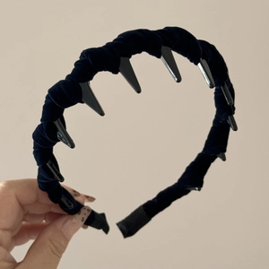 Detailed close-up of a black velvet headband with sharp wave teeth punk style design