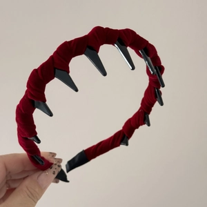 Close-up detail of red velvet headband showing inner black grip teeth and soft texture