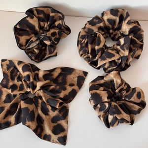 Set of four vintage leopard print hair scrunchies on a clean white background