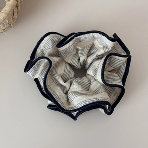 Detailed macro view of the striped fabric texture and stitching on the retro scrunchie