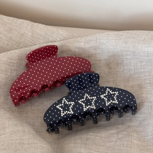 Détail de pinces à cheveux en acétate à pois rouges et étoiles en strass bleu marine