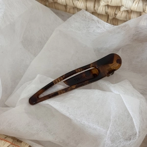 Close-up of leopard pattern hair clip with TCB-1334 engraving on high-quality acetate