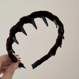Detail view of dark brown velvet twisted headband showing internal plastic grip teeth