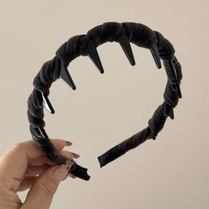 Detail view of black velvet wavy headband with inner teeth for secure non-slip hair styling