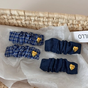 Set of four blue fabric hair clips with gold heart accents and various texture patterns