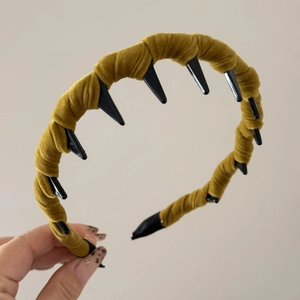 Detailed texture of mustard green velvet fabric wrapped on a wavy toothed headband accessory