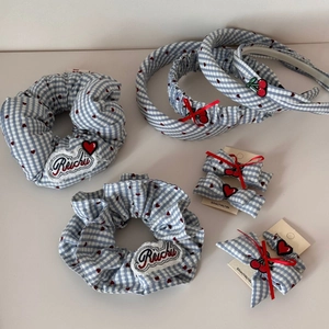 Dettaglio del set accessori capelli a quadri blu con ricami di cuori e ciliegie rossi