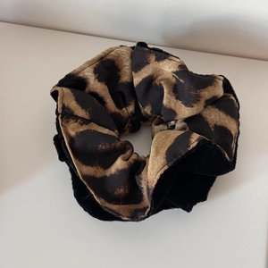Detail view of leopard print scrunchie featuring mixed fabric textures and high elasticity